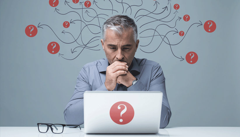 photo illustration of a middle-aged man sitting before a laptop with arrows and question marks in red circles around his head